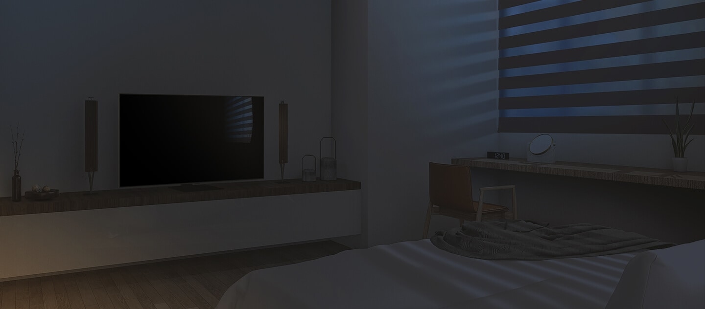 The interior of a clean bedroom with a bed, TV, and more. It is dawn, the blinds are down, and the TV is turned off.