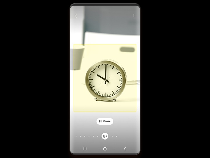 A phone screen shows a small desk clock identified by Bixby Vision, with a pause button below the image.