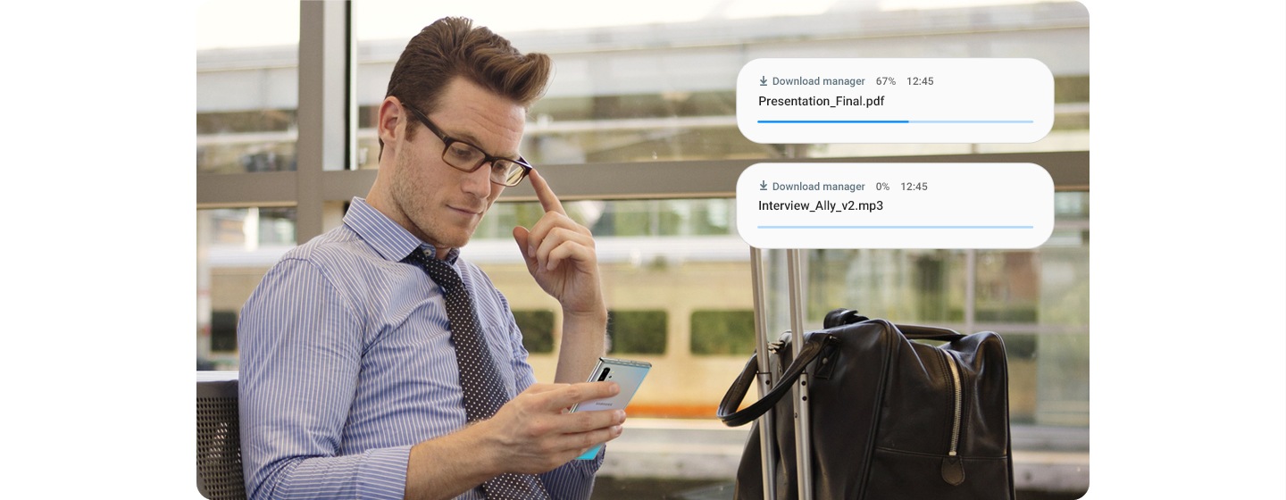 Man holding Galaxy Note10+. Download manager notifications appear showing two items being downloaded at the same time thanks to the improved data speeds.