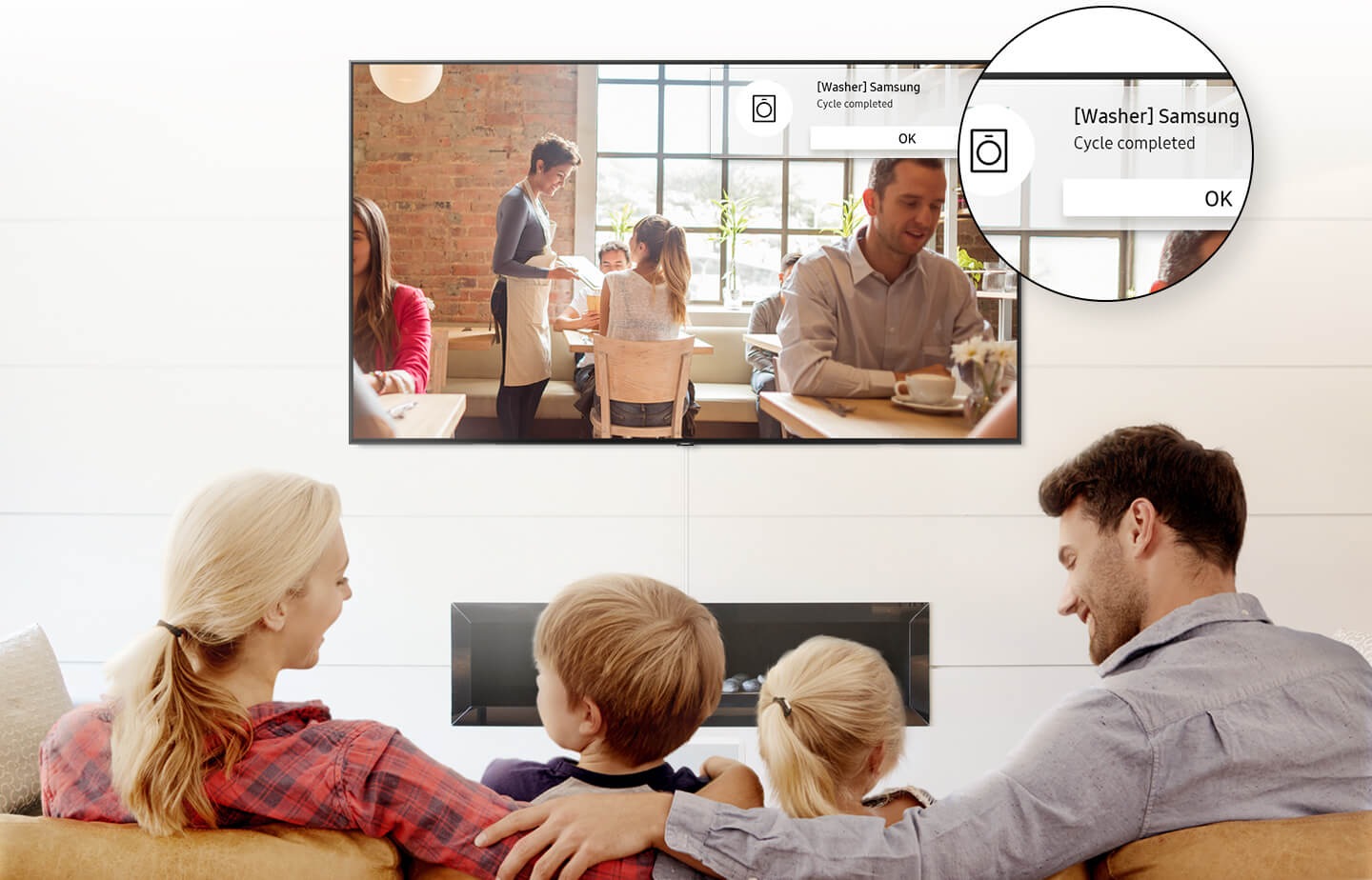 4 people are watching Smart TV with a pop-up alarm showing Washer's cycle has been completed.