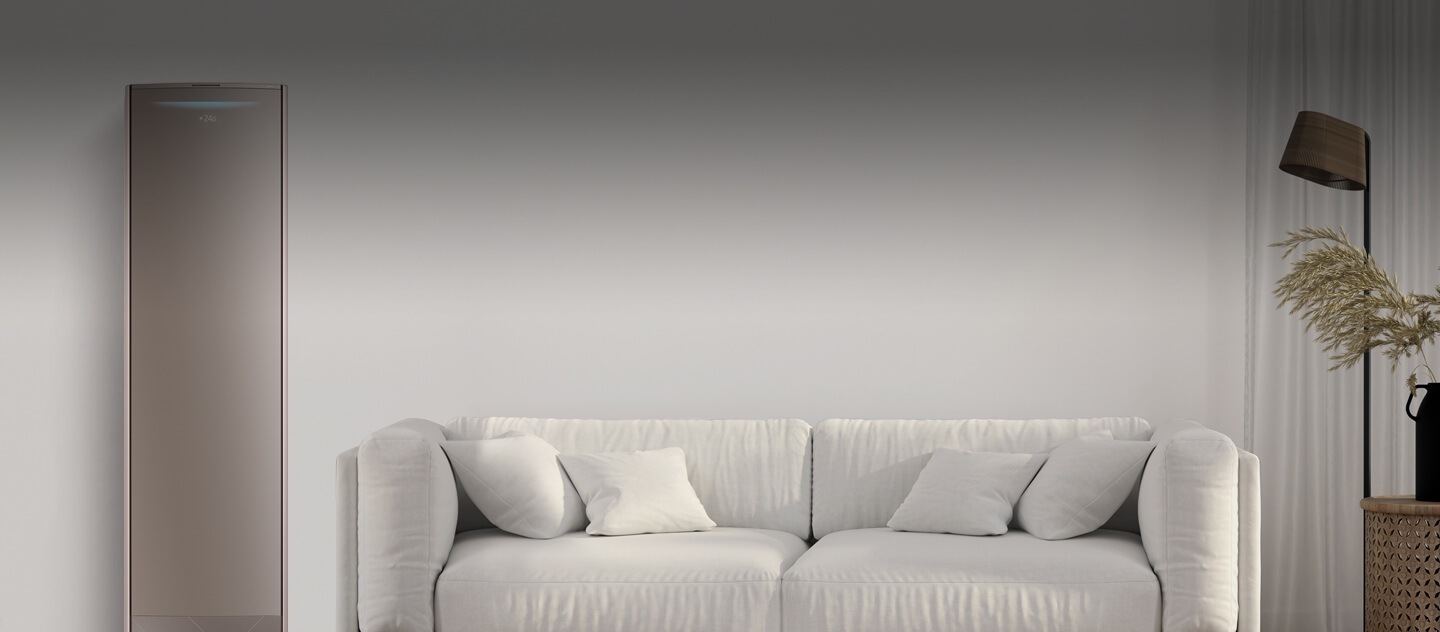 Un salon avec un divan blanc au centre, une lampe et une plante du côté droit et un climatiseur intelligent sur la gauche.