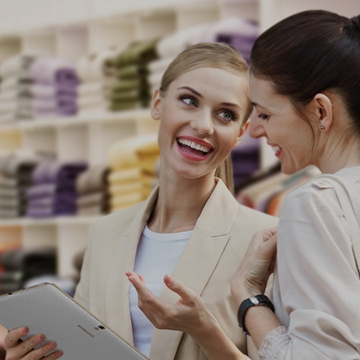 Un commis renseignant un client sur les produits en utilisant un appareil mobile Samsung
