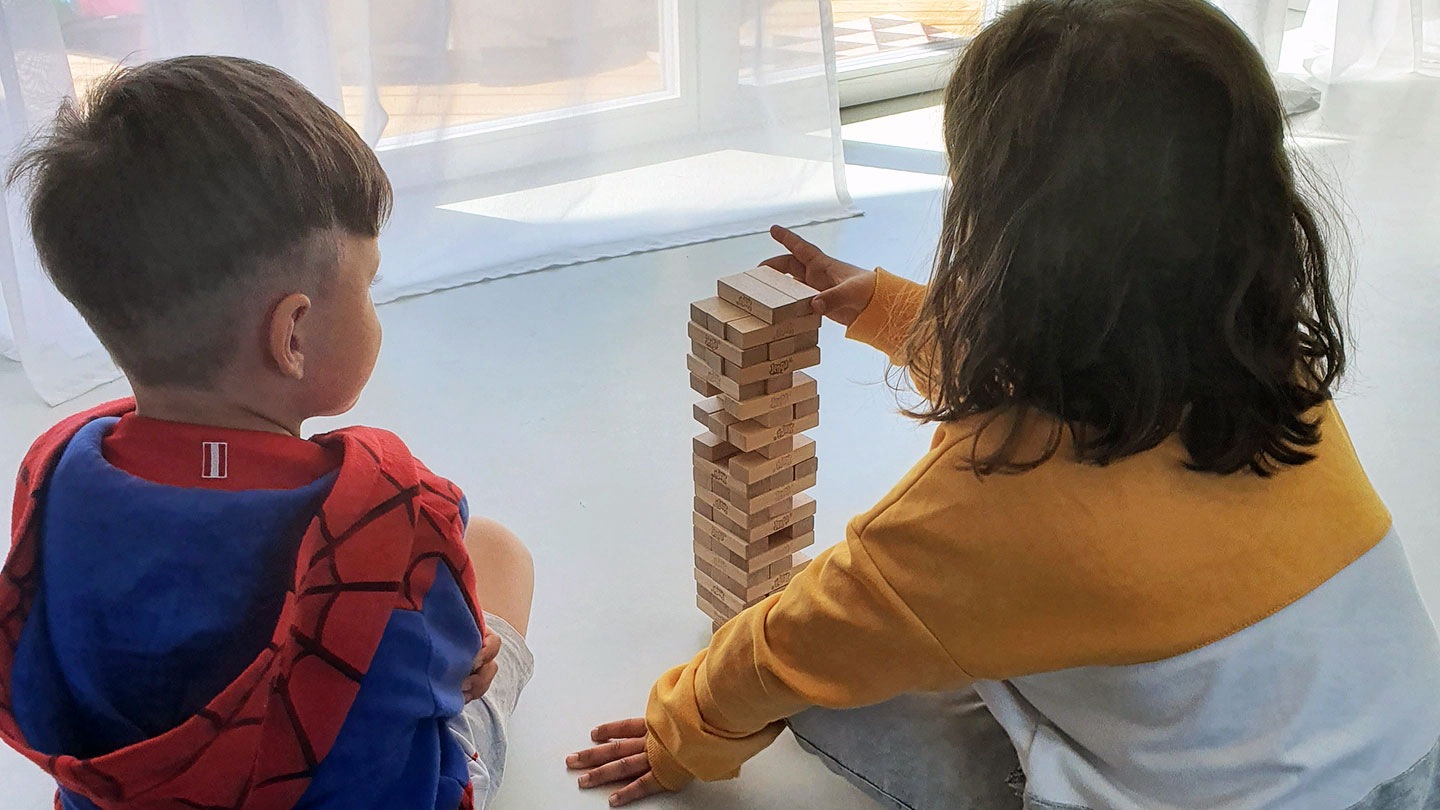 Kinder spielen gemeinsam Jenga.