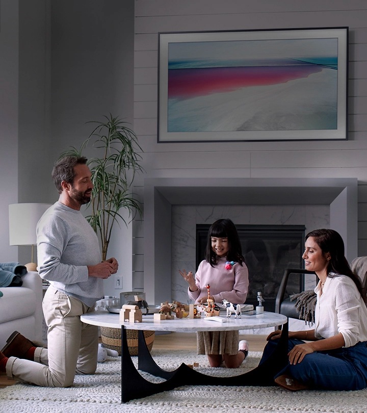 The Frame TV hängt an der Wand im Wohnzimmer und ist im Art Mode. Es wird ein Kunstwerk auf dem Bildschirm gezeigt, das den Raum verschönert.