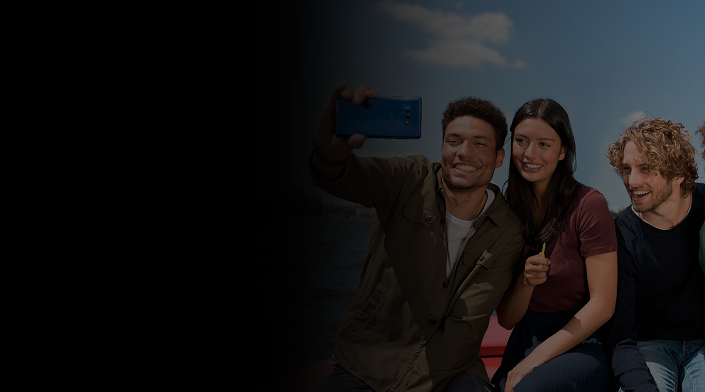 Registros para extranjeros Se muestran tres extranjeros que se están tomando una fotografía selfie con el S Pen