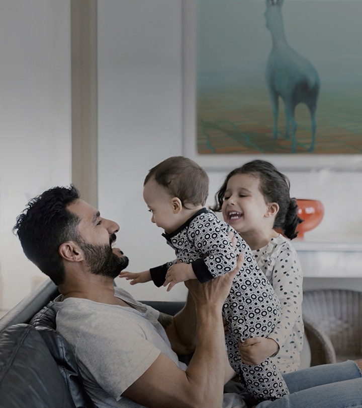The Frame está colgando de una pared mostrando arte. Hay una familia sonriendo en el sillón de la casa.