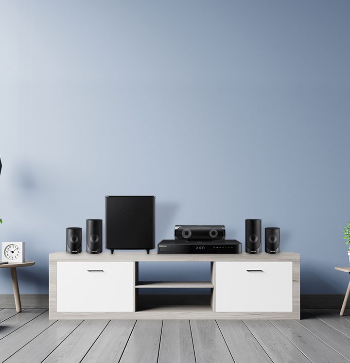 Frontal de sistemas Blu-Ray y Home Theatre que están sobre un mueble de madera. El mueble está apoyado sobre un piso de tablas de madera.