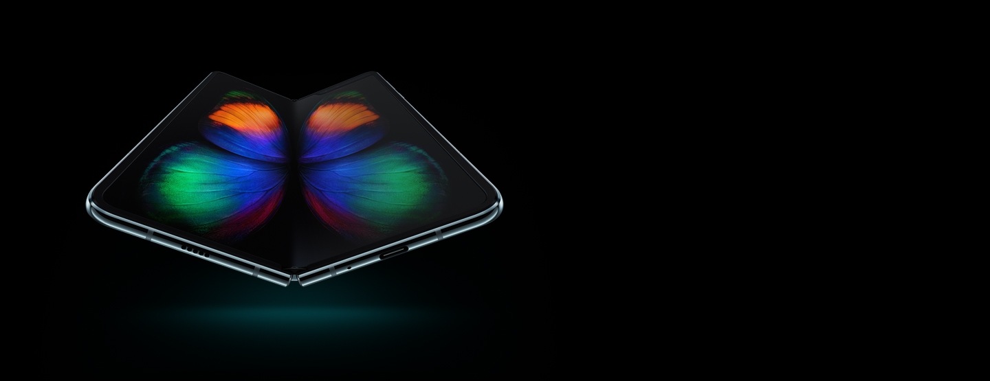 Un teléfono Galaxy Fold de color plata espacial visto en un ángulo ligero desde abajo, con una gráfica de una mariposa multicolor en pantalla.