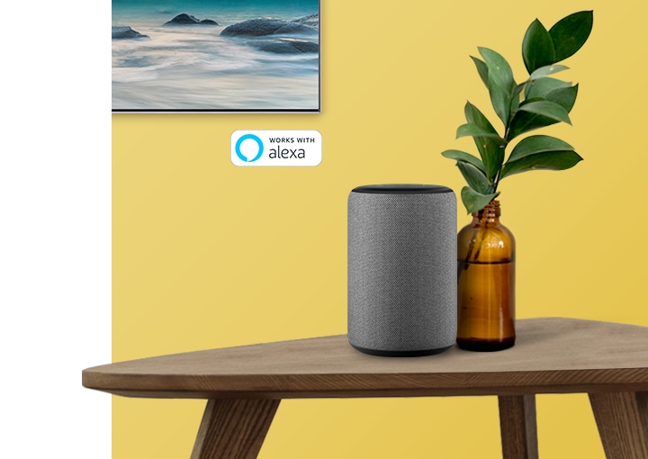 Aparece Alexa (Amazon) en una mesa de madera, conectado a un televisor inteligente Samsung 2019.