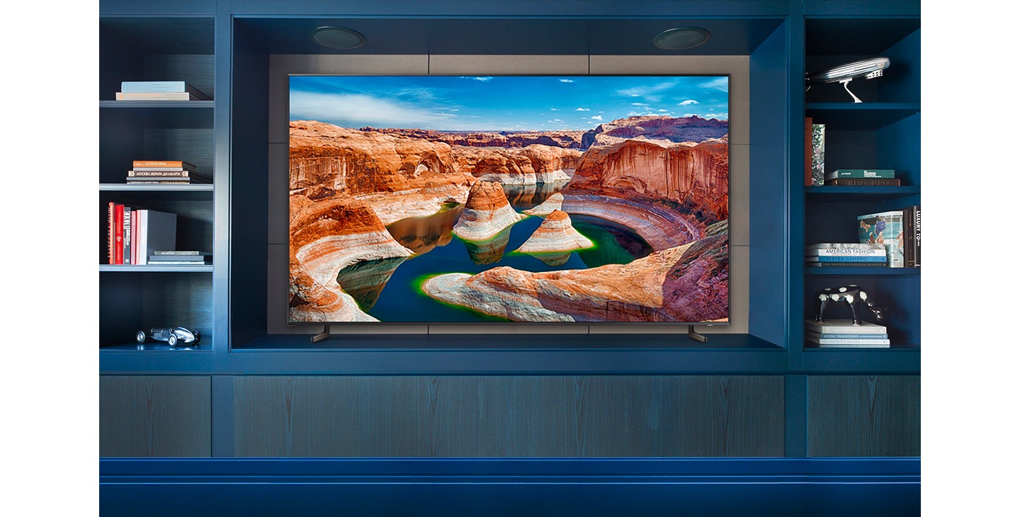 Un televisor de pantalla grande muestra cómo calcular el ancho y la profundidad del soporte en el que se colocará al revisar las dimensiones del aparato. Se muestra que el tamaño del mueble para el televisor debería ser más grande que el ancho, el alto y la profundidad reales del televisor con bisel incluido.