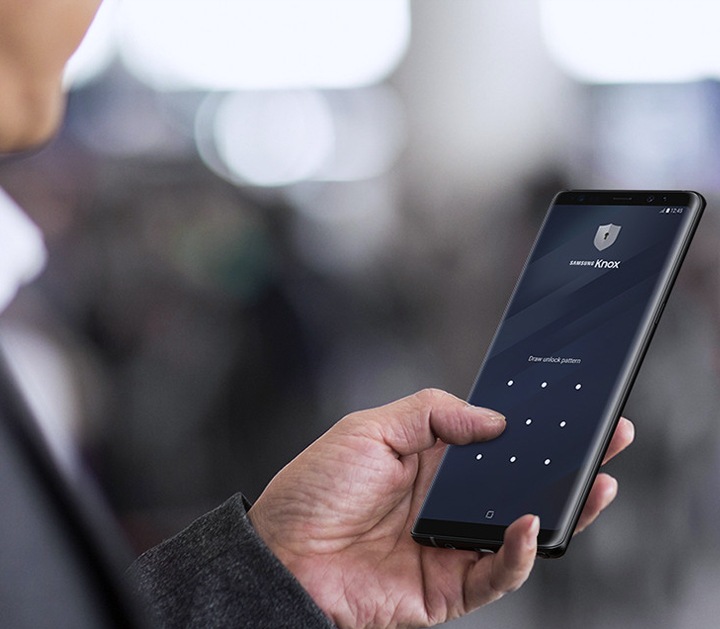 Ein Mann, der auf sein Samsung Smartphone tippt, dessen Bildschirm mit der Samsung Knox-Lösung gesichert ist
