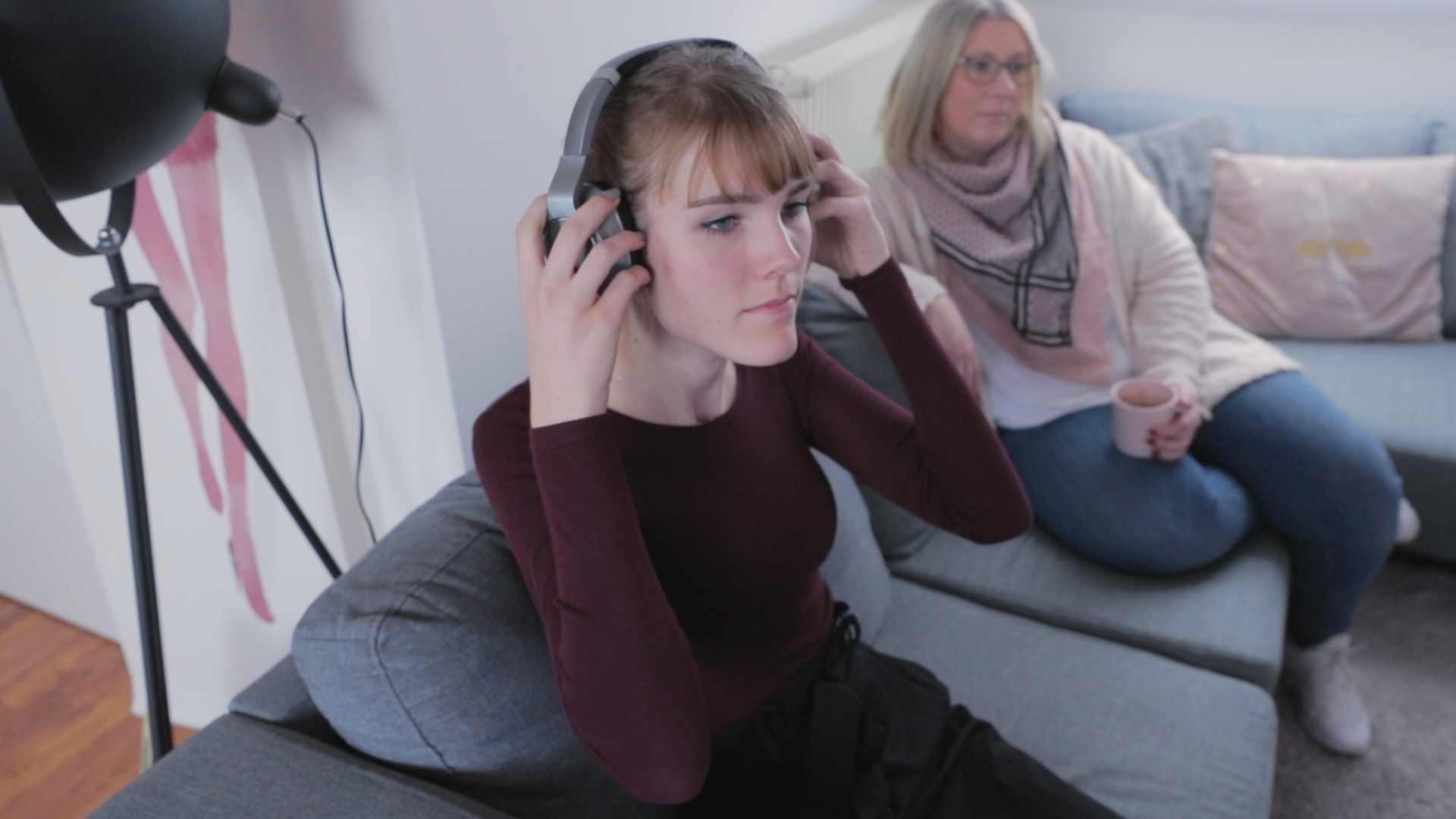 Maike_Hartwig_01 – Maike beim Fernsehen mit Kopfhörer in ihrem Wohnzimmer