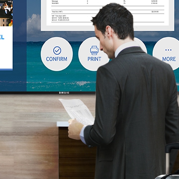 Un empresario con una maleta realizando el registro de entrada en un hotel mediante una Smart Signane TV de Samsung