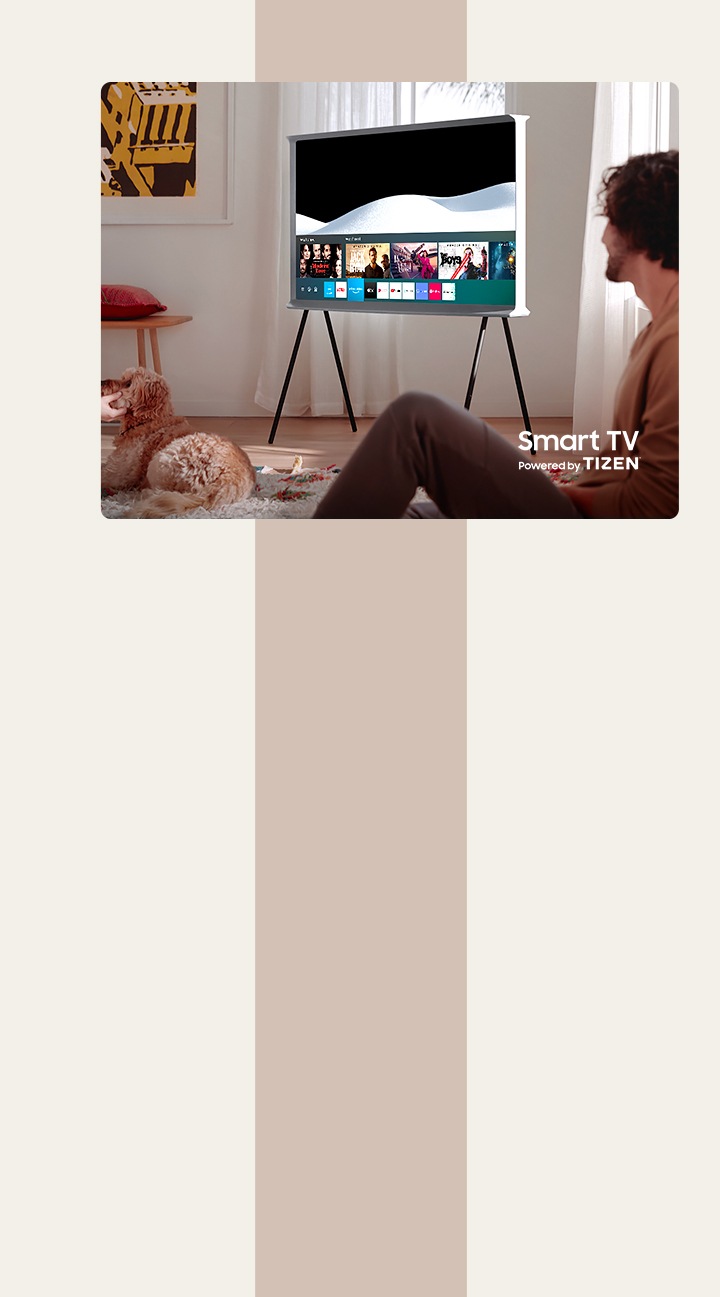 Un hombre está disfrutando de su tiempo juntos en una sala de estar. Un The Serif Cloud White está en el centro de la habitación con la pantalla de Smart Hub de Samsung abierta. El televisor The Serif es un televisor inteligente que funciona con Tizen.