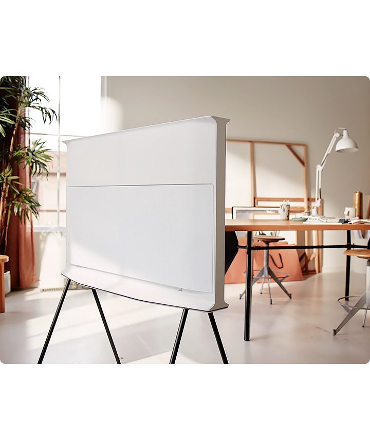 Un The Serif 2020, televisor blanco Samsung, está de pie en medio de una habitación con la parte trasera a la vista. El diseño integral 360 hace que la parte trasera del televisor tenga estilo.