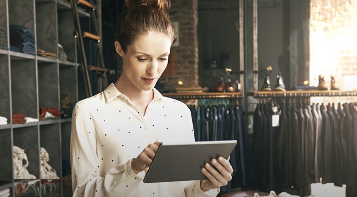 Une femme tient une tablette dans un magasin