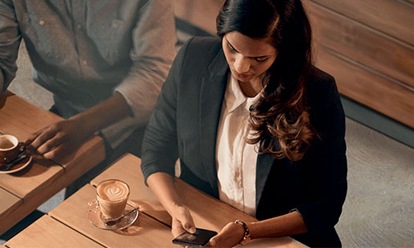 Jeune femme sur son téléphone dans un café