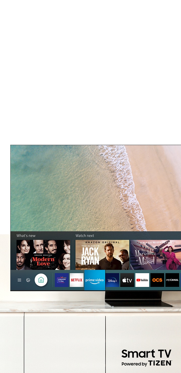L’écran du téléviseur QLED Samsung affiche le Smart Hub. Le logo « Smart TV fonctionne sous TIZEN » est affiché sous le téléviseur.