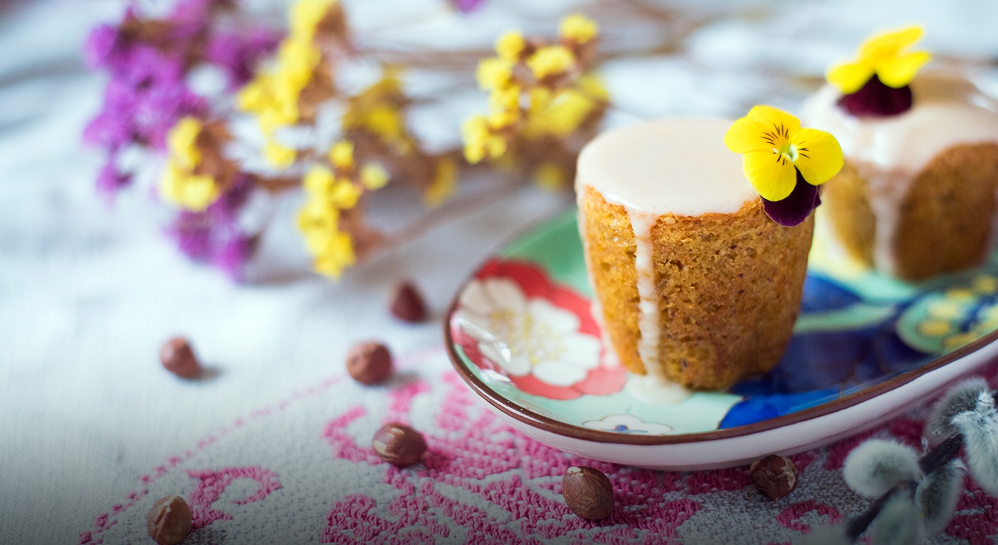Dos magdalenas de zanahoria con glaseado de naranja en un plato decorativo