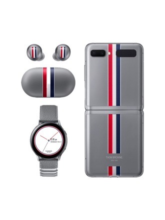 Vista posteriore di un Galaxy Z Flip Thom Browne Edition grigio accanto ai suoi Buds+ e al Galaxy Watch Active2 a sinistra