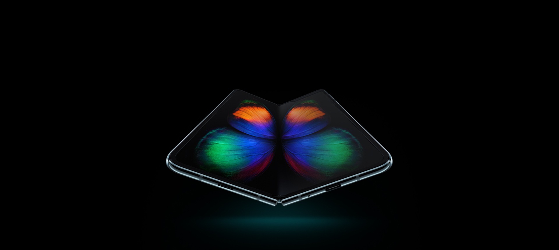 Das Galaxy Fold ist geöffnet aus einem leichten Winkel von unten zu sehen. Das Display zeigt die Schmetterlingsgrafik in Graustufen. Die Animation startet mit einer Nahaufnahme des Infinity Flex-Displays und zoomt dann heraus, sodass das ganze Smartphone zu sehen ist.