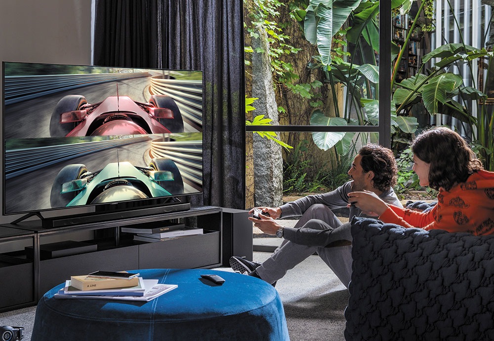 En mann og en kvinne som spiller et spill på en Samsung Smart TV
