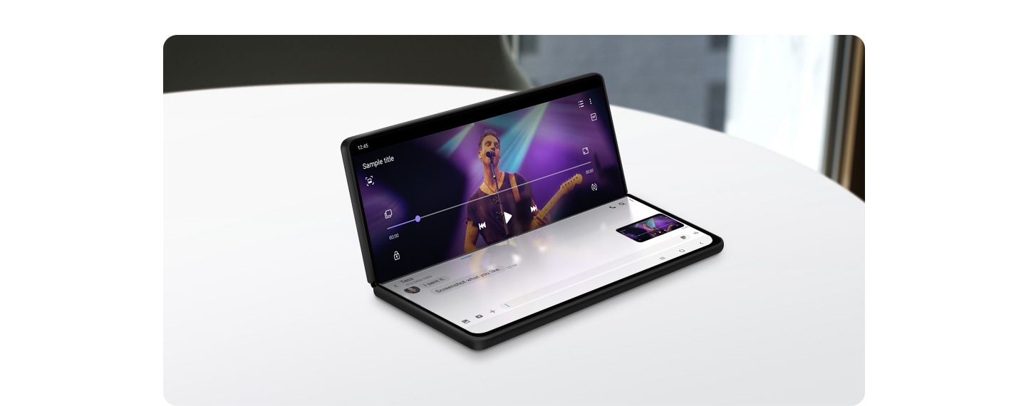 一部 Galaxy Z Fold2 裝置放於桌上,頂屏幕大致垂直摺疊擺放。上半部分播放影片,下半部分則展示留言。