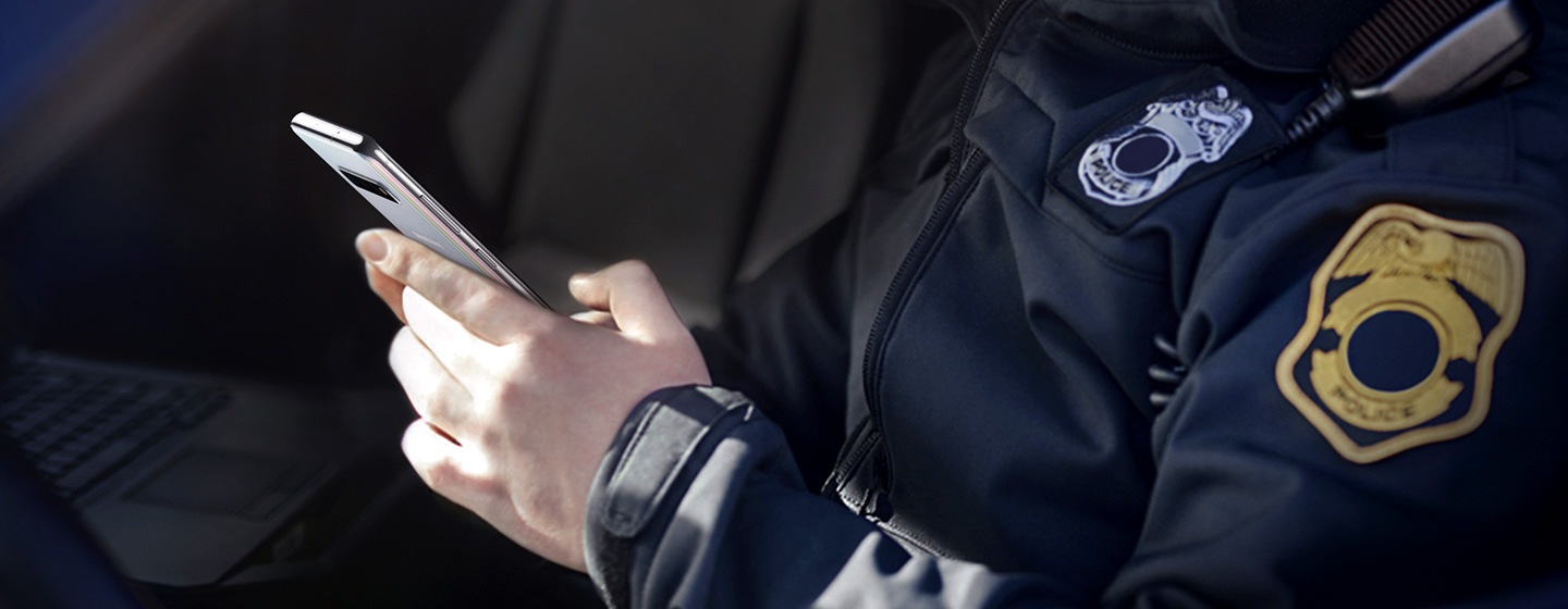 Image of police officer using Galaxy S10 plus while sitting in his car.
