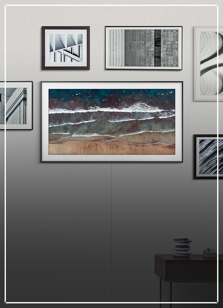 一部2020 Samsung The Frame TV掛在牆上,屏幕呈現著畫作,並與其他藝術品和畫框融為一體。