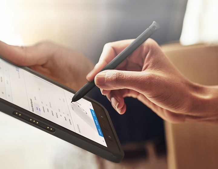 A woman signing on a digital receipt handed over by a man holding a box