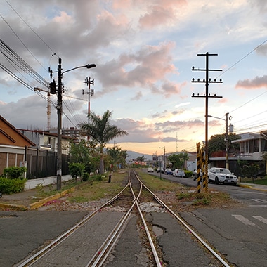 A photo captured with Galaxy by Instagram user @ry_ty_on_tour looking down train tracks running through a neighborhood at sunset