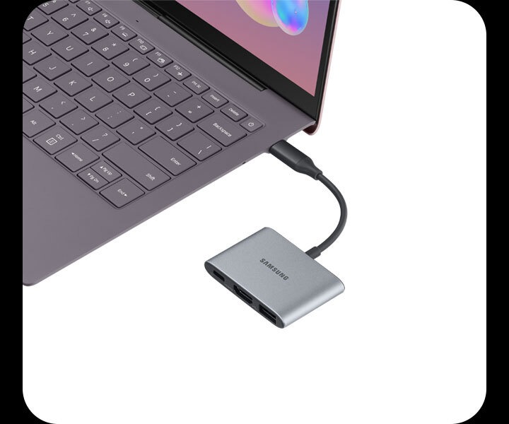 A grey Samsung Multiport Adapter plugged into a grey Galaxy Book laptop which is only partially pictured A grey Samsung Multiport Adapter plugged into a grey Galaxy Book laptop which is only partially pictured