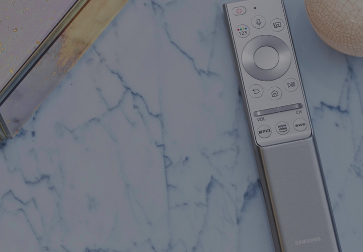 Samsung smart TV remote in silver on marble background