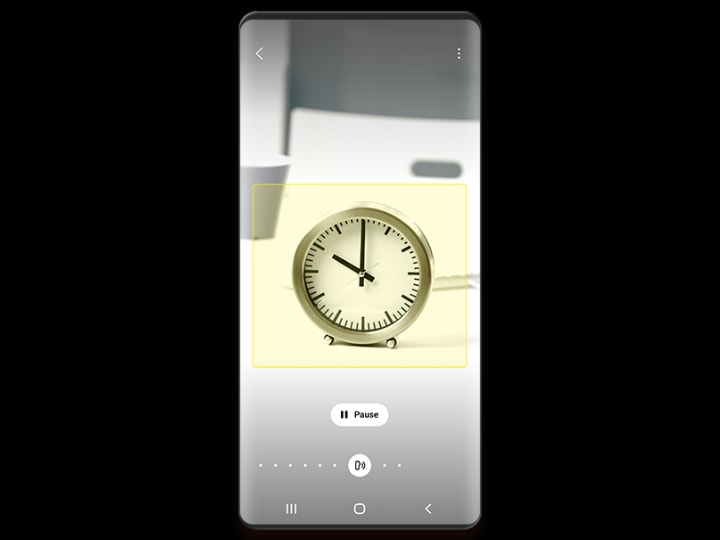 A phone screen shows a small desk clock identified by Bixby Vision, with a pause button below the image.