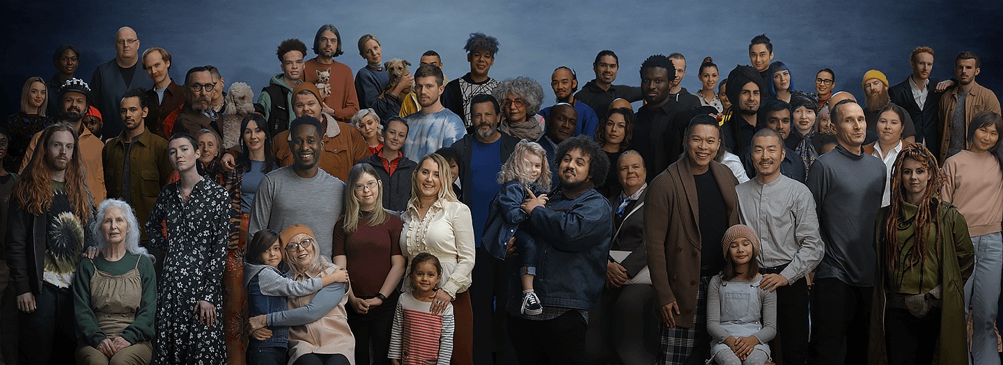 Several people of different ages, genders and ethnicities are standing in groups looking straight at the camera.