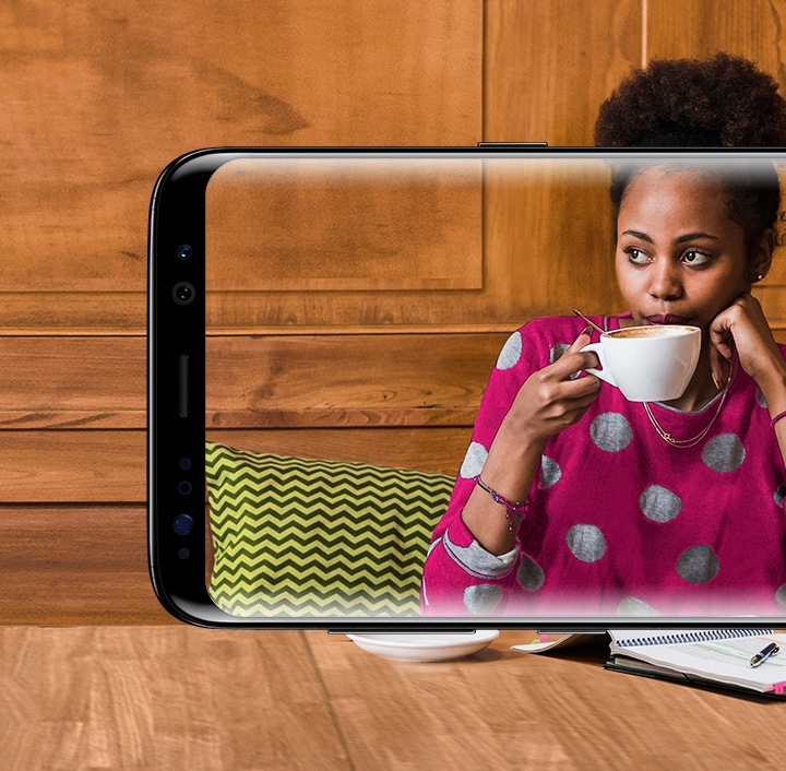 Lo schermo di uno smartphone Samsung Galaxy S8 che raffigura una donna mentre sorseggia un caffè in un bar