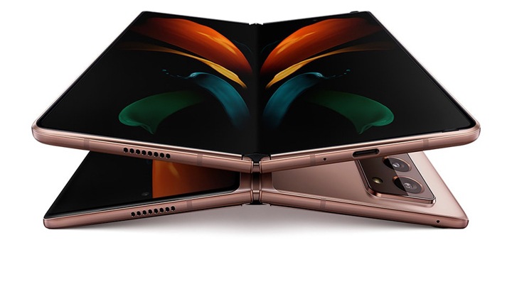 Galaxy Z-Fold2 Два разгънати телефона Galaxy Z Fold2 в мистичен бронз – единият с екрана нагоре, другият – надолу. Гледаният отпред, се намира върху другия, който е с екрана надолу, и на екрана му се вижда красив тапет с пеперуда.
