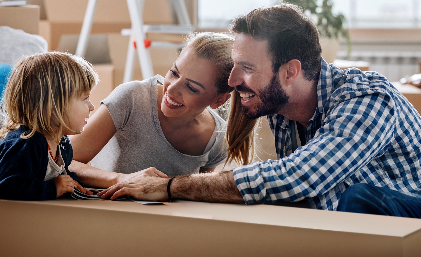 due genitori parlano sorridenti con il loro bambino