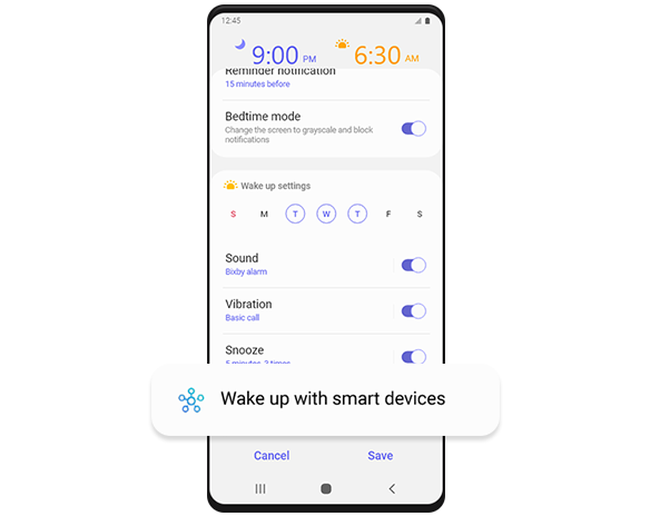A Galaxy smartphone screen showing the 'Wake up with smart devices' settings page. Under 'Devices to control,' it reads, "Turn on TV," "Turn on lights," and "Open blind." All three commands are enabled and below each command reads, respectively, "Bedroom TV," "Bedroom Light, Bedroom bulb," and "Bedroom blinds." Below "Devices to control," "More options" give the following setting options that are currently disabled: "Run only when you're at My Home," and "Run when alarm dismissed."