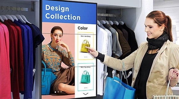 Женщина, нажимающая на изображение продукта на дисплее Samsung SMART Signage во время похода по магазинам