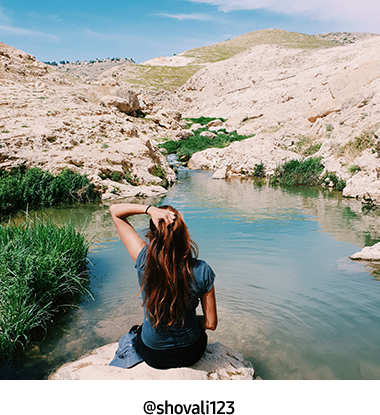 A photo captured with Galaxy by Instagram user @shovali123 of a girl sitting on a rock in front of a small waterway and rocky hills