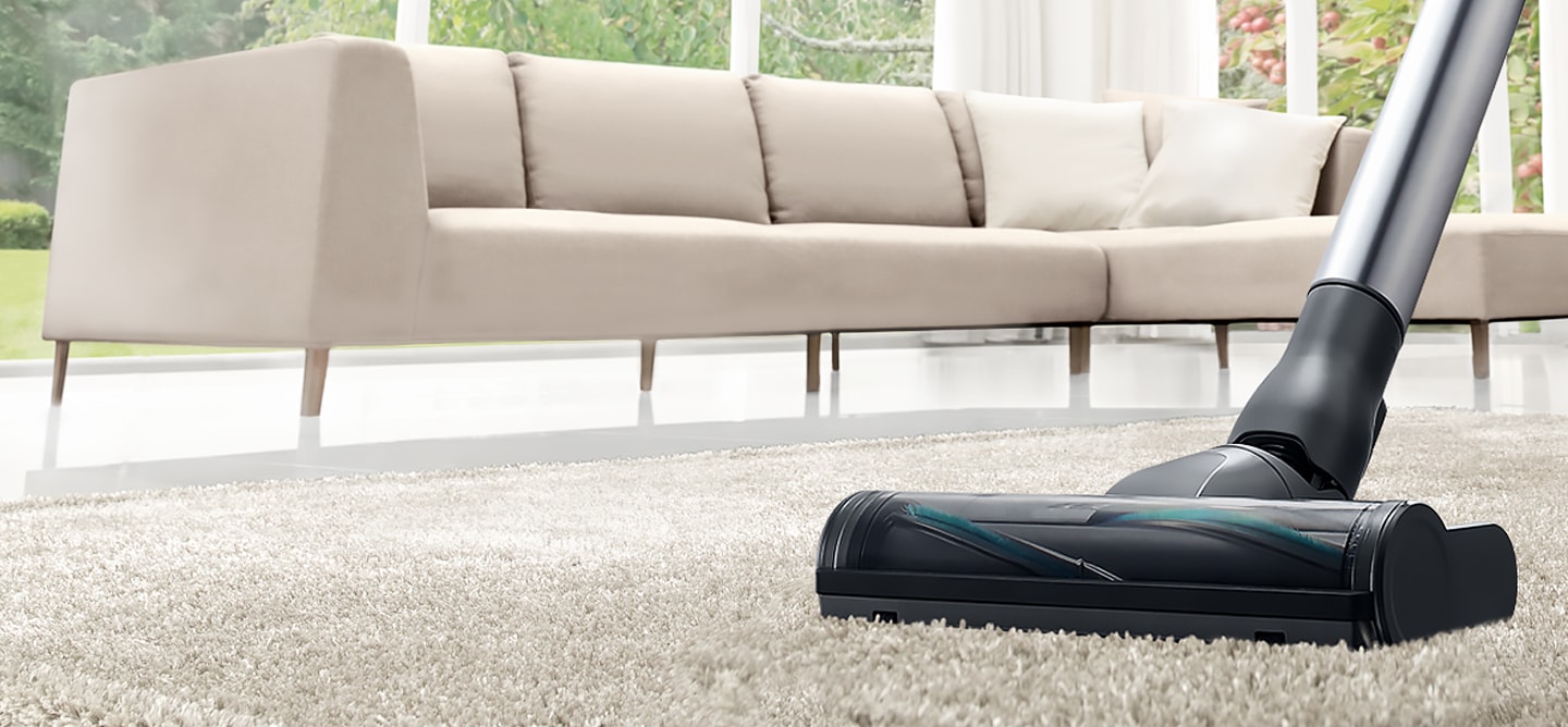 Modern interior living room with Samsung vacuum cleaner. Dynamic angle of Samsung silver vacuum cleaner cleaning carpet in modern interior living room