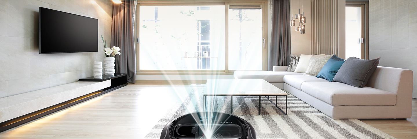 Front angle photo of modern living room with Samsung robot vacuum cleaner. Modern family living room designed with silver Samsung robot vacuum cleaner.