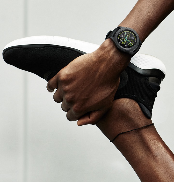 سيدة تمارس تمارين الإطالة وتمسك قدمها في يدها، مرتديةً على معصمها ساعة Galaxy Watch