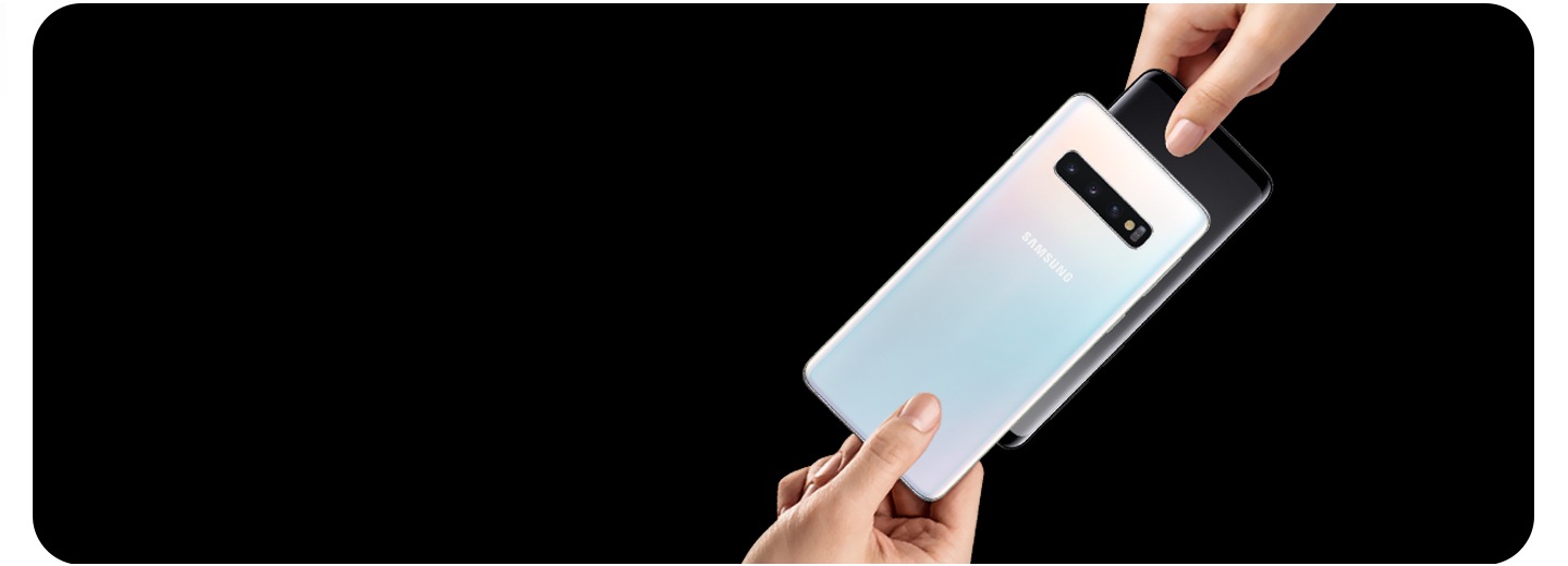 Atnaujinkite į „Galaxy“ Dvi rankos, apsikeičiančios „Galaxy“ telefonais juodame fone.