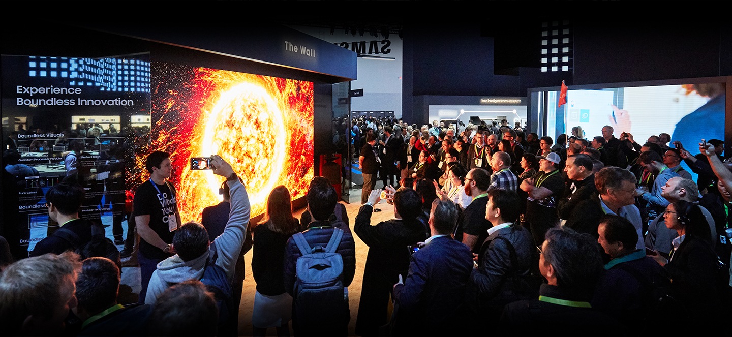 Un amplio grupo de asistentes se reúne alrededor de The Wall 2019, que se exhibe en la zona VD del pabellón de Samsung en el CES 2019.