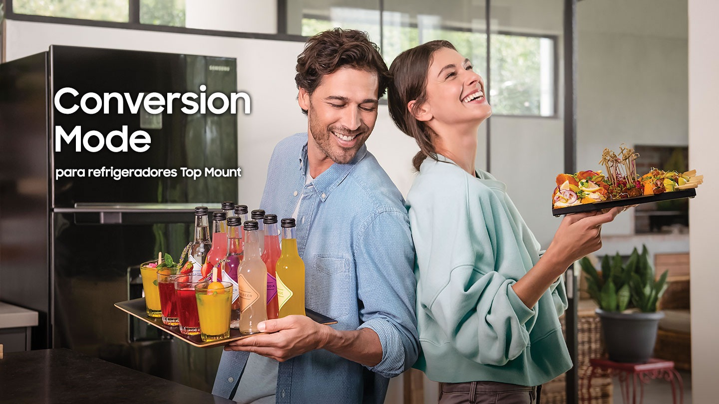 La imagen ilustra Conversion mode del refrigerador Top mount Samsung. En ella, una pareja está de pie al frente de la imagen y sostenienen una bandeja que contiene bebidas de fiesta.