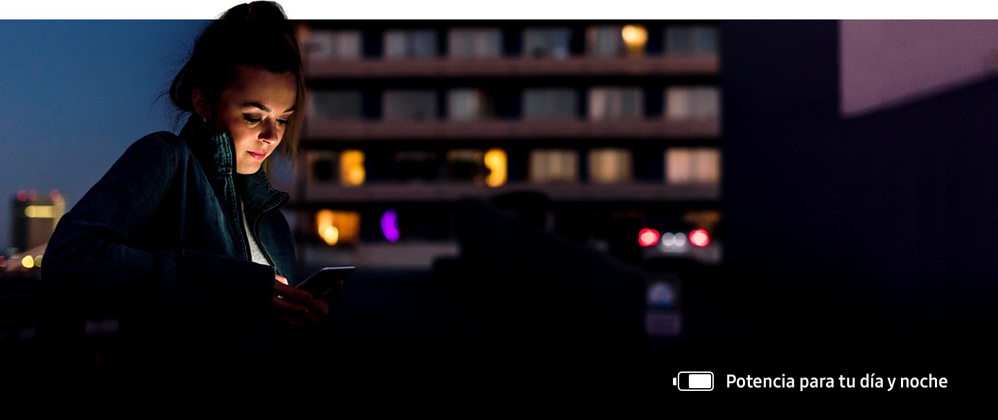 Imagen de una mujer que usa su teléfono en exteriores en la noche. El ícono de batería en la esquina inferior derecha muestra que aún cuenta con suficiente carga.