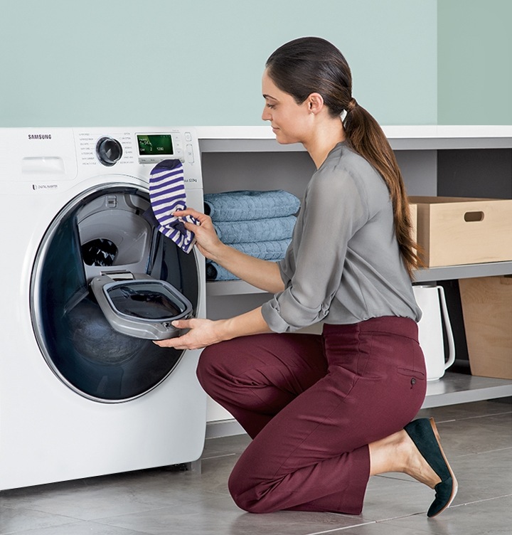 Add Wash Una mujer añadé a la carga de lavado en curso un par de calcetines a través de la puerta AddWash.