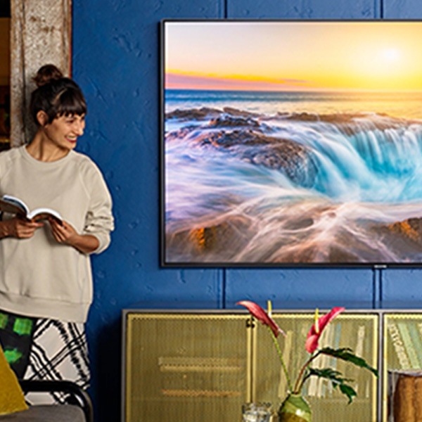 Lady standing beside Samsung QLED TV